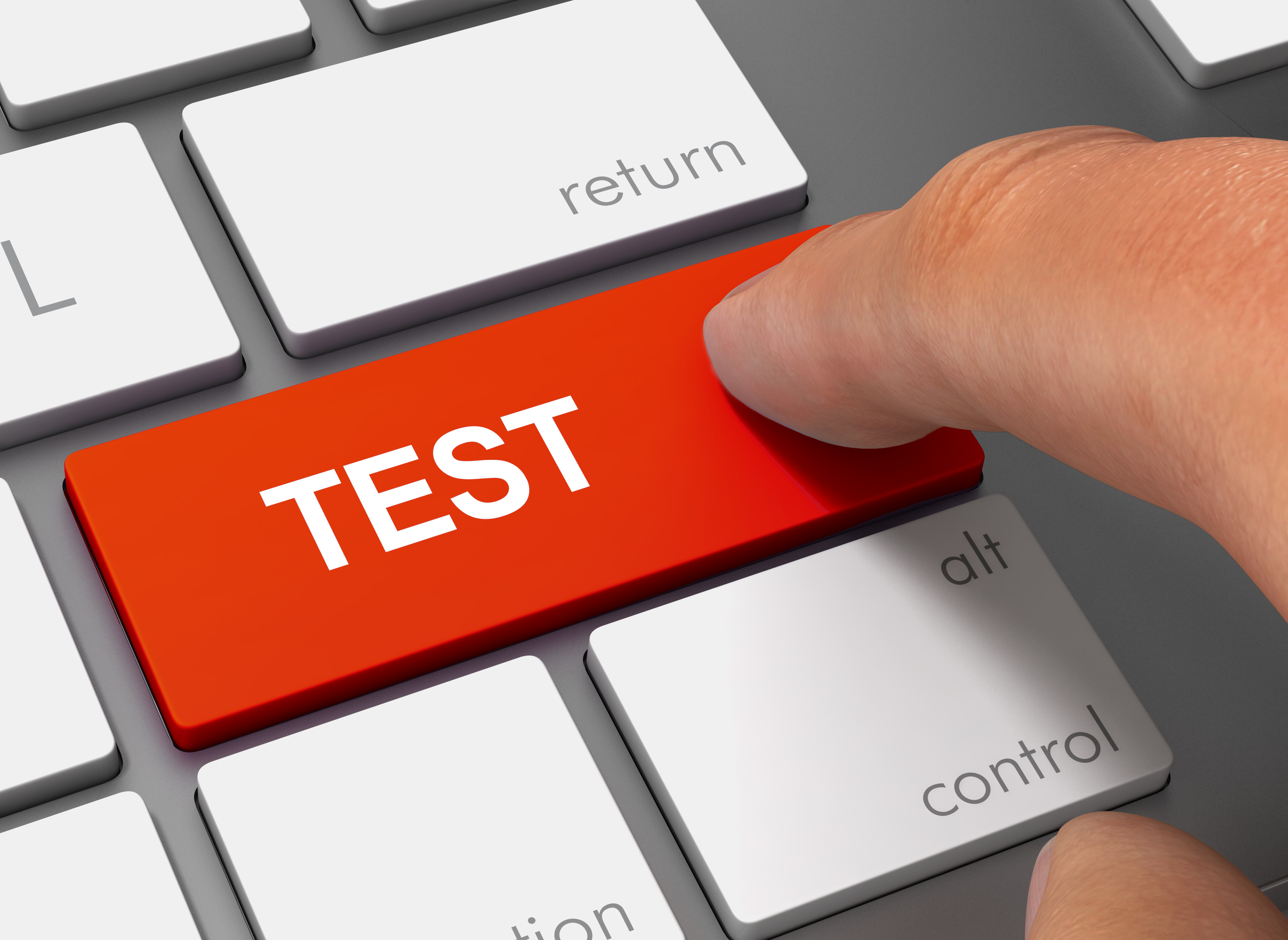 A keyboard with a big read key with the word Test written, and there a finger pressing it